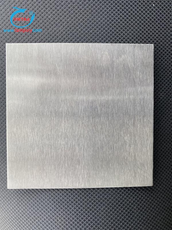 Một chuyên gia in ấn đang tư vấn cho khách hàng, tay chỉ vào các mẫu vật liệu Mica, Alu, Inox trên bàn