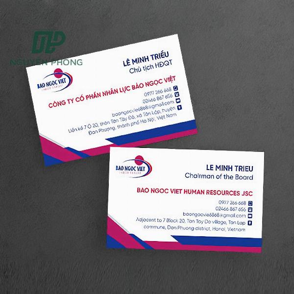 Một nhà thiết kế đang cầm và xem xét các mẫu vật liệu in name card khác nhau dưới ánh sáng tự nhiên